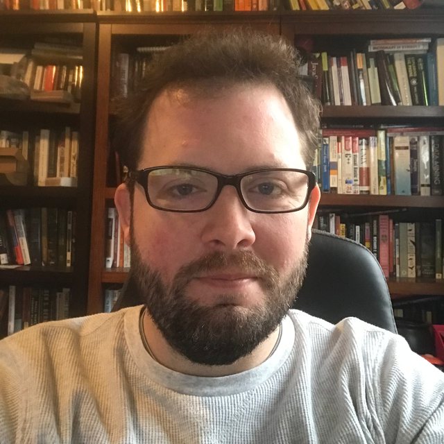 Portrait of Robert Hoekstra in front of a wall of programming and data books.